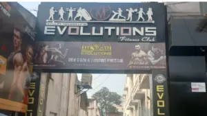 Evolutions Fitness Club gym entrance signage in Coimbatore with fitness transformation banner and contact details