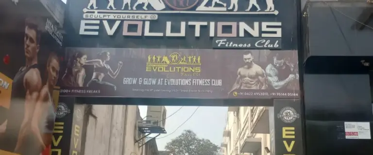 Evolutions Fitness Club gym entrance signage in Coimbatore with fitness transformation banner and contact details