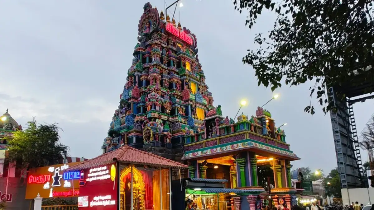 Perur Arulmigu Pateeswaraswamy Temple gopuram illuminated at dusk in Coimbatore, Tamil Nadu, showcasing traditional Dravidian temple architecture