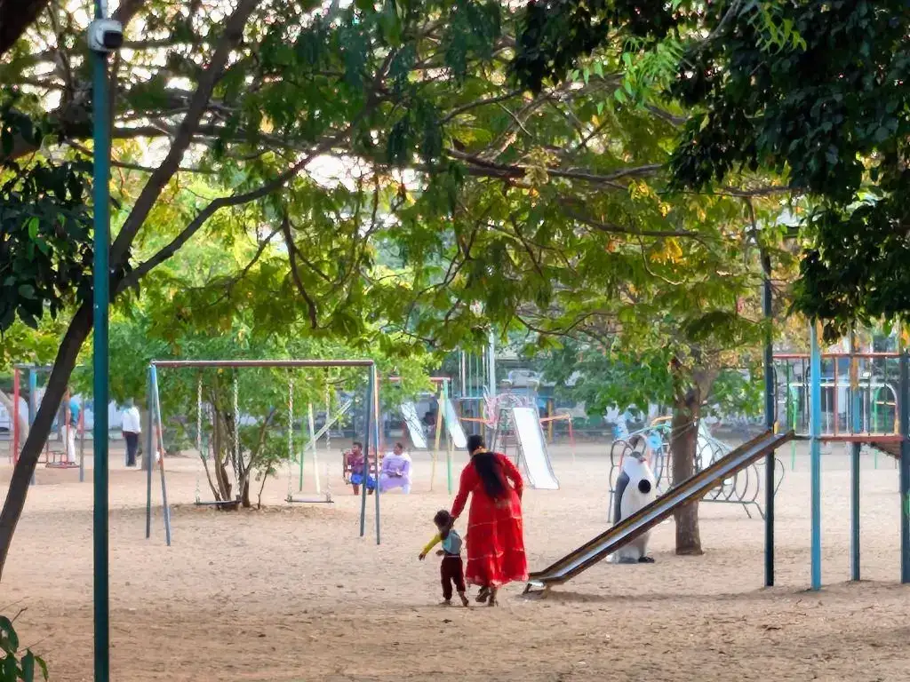 Children playing at VOC Park Coimbatore playground under shaded trees