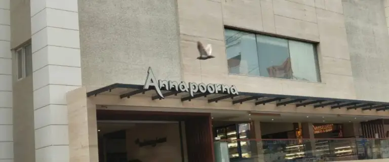 Annapoorna restaurant building exterior with its sign above the entrance and a bird logo on the facade