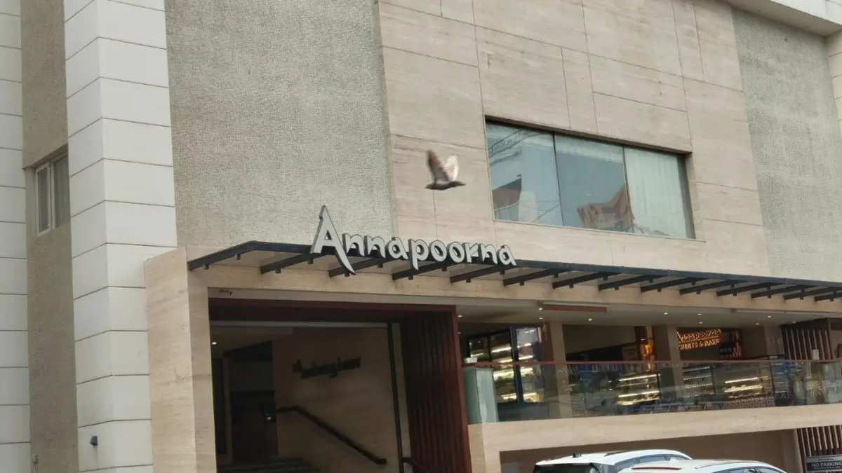 Annapoorna restaurant building exterior with its sign above the entrance and a bird logo on the facade