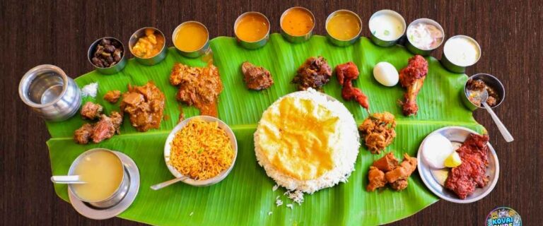 South Indian banana leaf meal with rice, biryani, sambar, rasam, payasam, curries, papad, and side dishes served on a fresh banana leaf – Coimbatore style